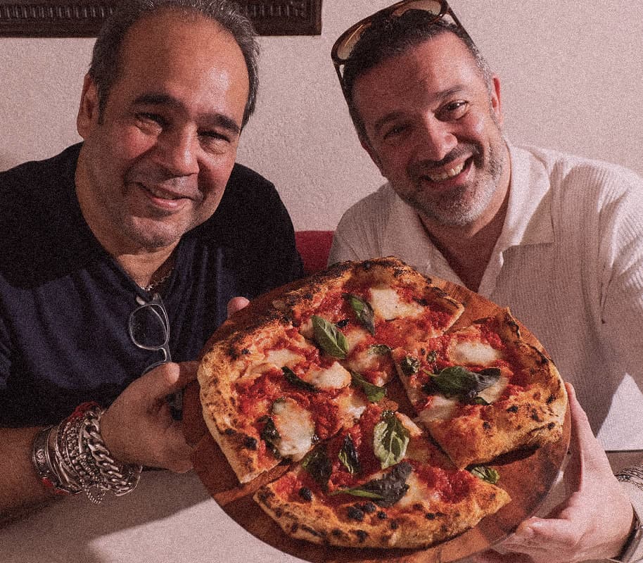 Mishal and Angelo, the founders of Amichi, holding a fresh Margherita